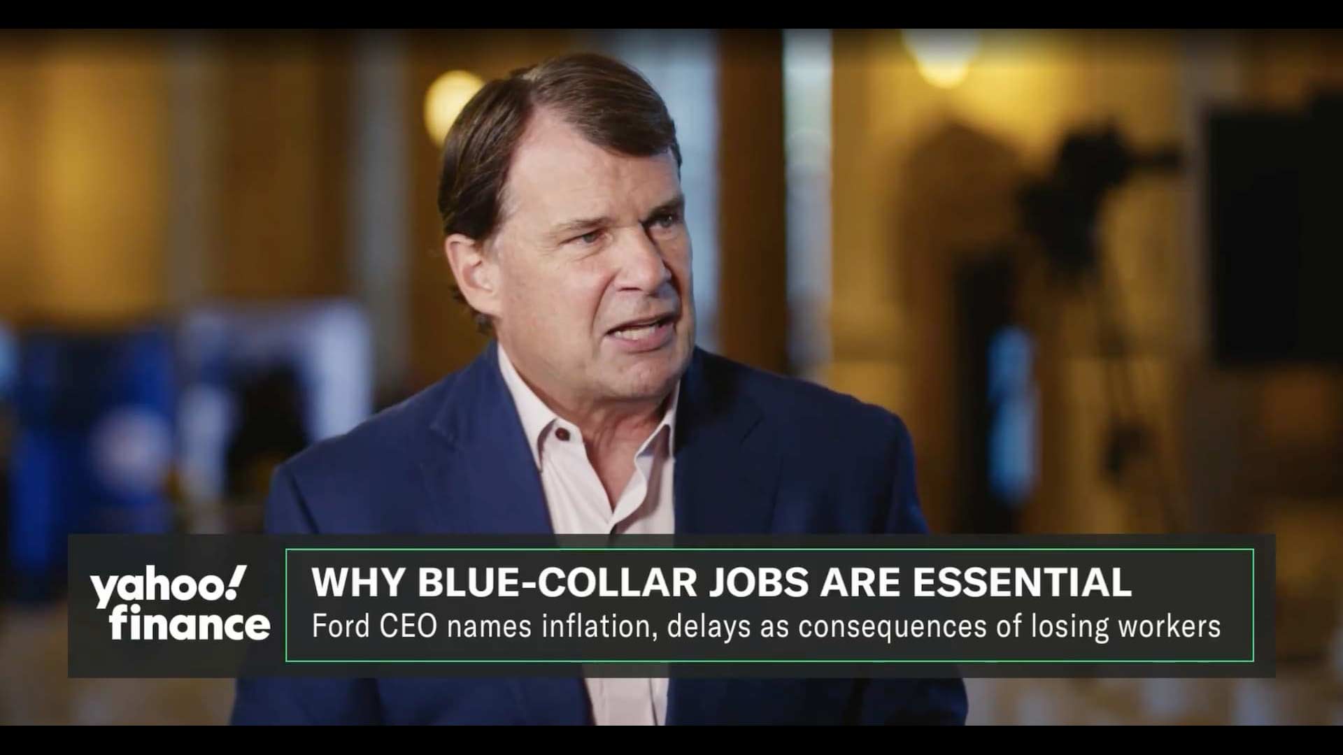 A man in a suit speaks in an interview on Yahoo Finance with the headline, "WHY BLUE-COLLAR JOBS ARE ESSENTIAL" and a subheading about the Ford CEO discussing the skilled trades crisis and worker shortages.
